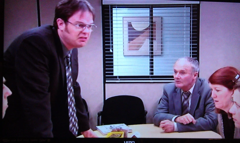 two men and a woman sitting in front of a tv monitor