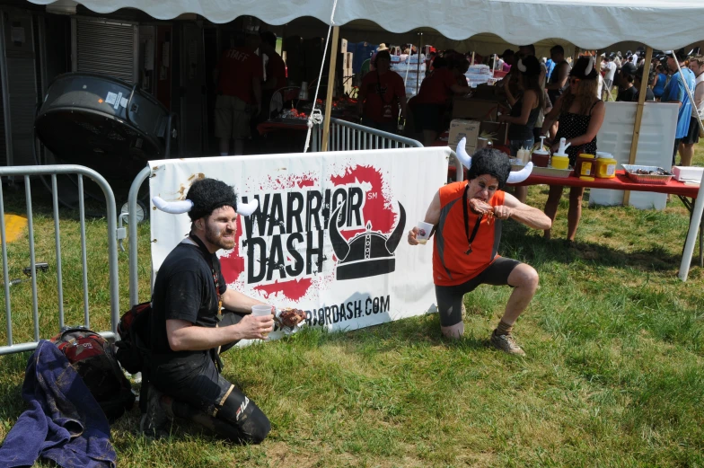 two men with a banner on their body posing for a picture