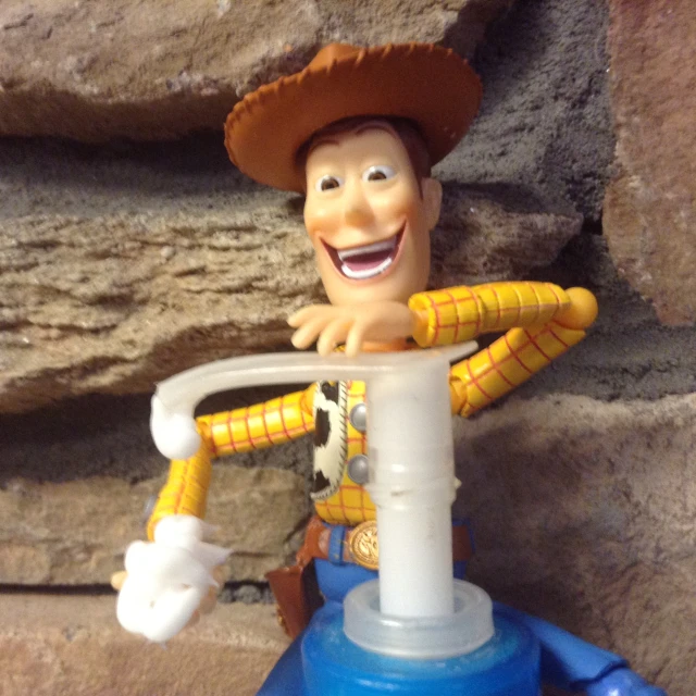 a toy figure wearing a cowboy hat and holding a hair dryer