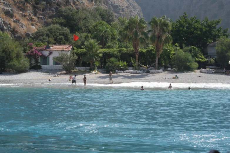 people are walking on the beach near the water