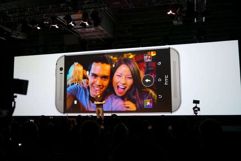 a huge screen showing a couple and two cameras