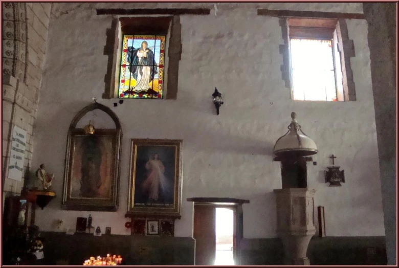 a small church with paintings and candles on the wall