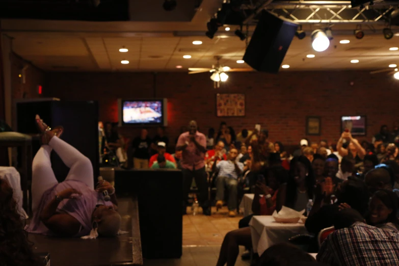 a large group of people sit in a room with lights on