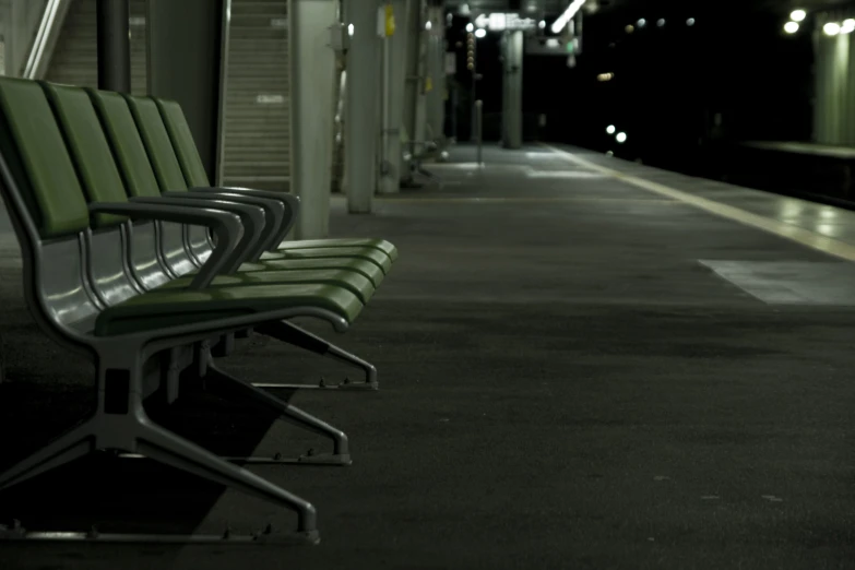 row of benches in middle of building at nighttime