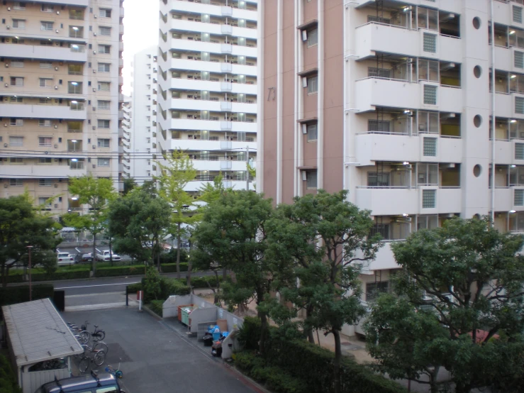 some very tall white and brown buildings with cars parked by them