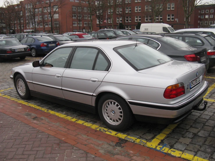 a silver car is parked in front of other cars