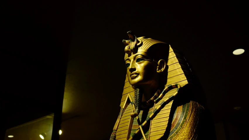 statue of the ancient egyptian pharaoh sitting in front of a building