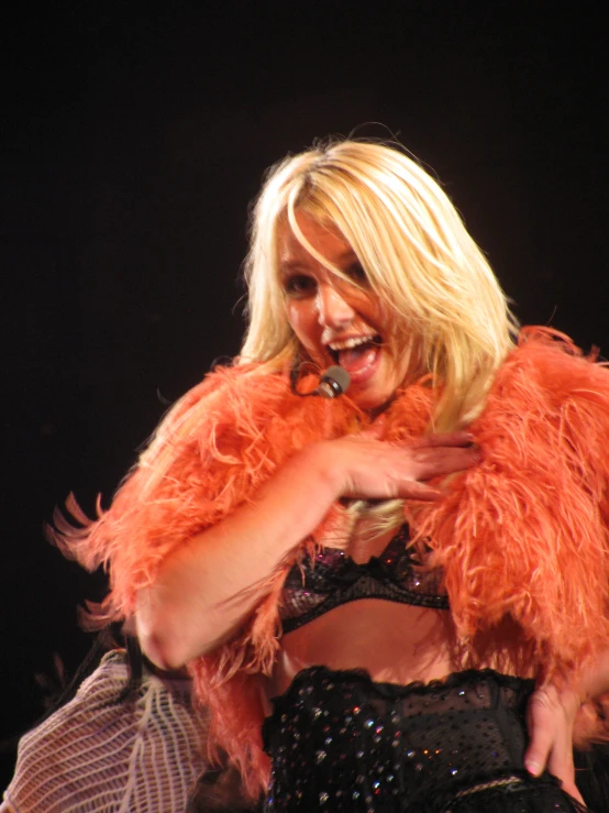 a beautiful blond woman wearing a fluffy orange jacket