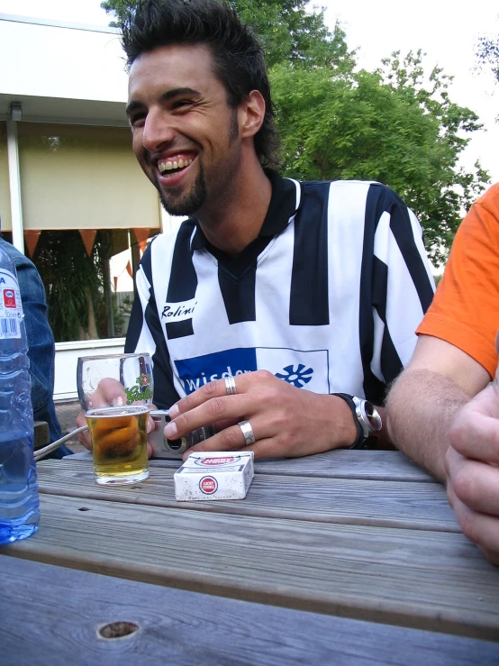 a young man with a smile on his face having a drink