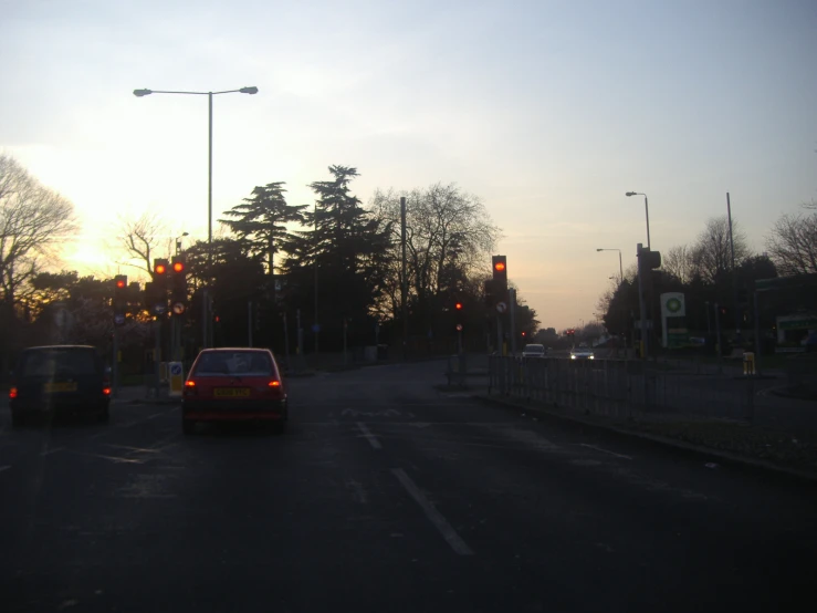 two cars driving on the road at dusk