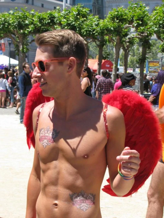 a man without a shirt wearing a red winged costume