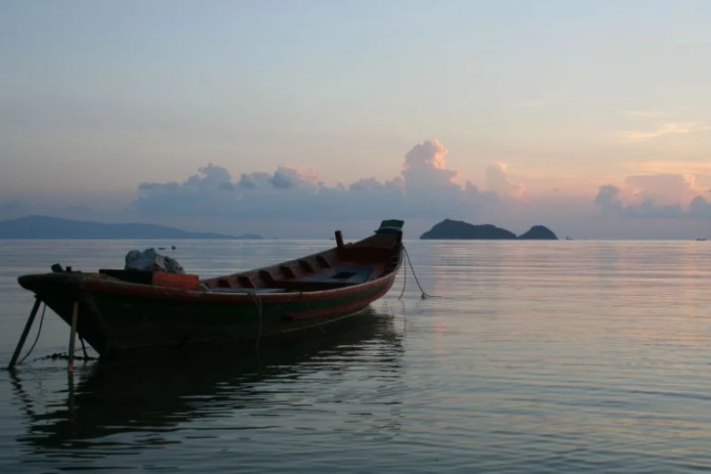 a small boat on the shore of a calm sea