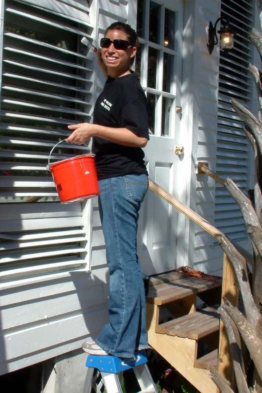 a man standing on a stepladder with a bucket