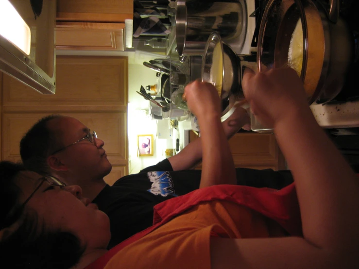 a couple of people preparing food in a kitchen