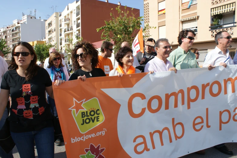 a group of people marching down the street holding a sign