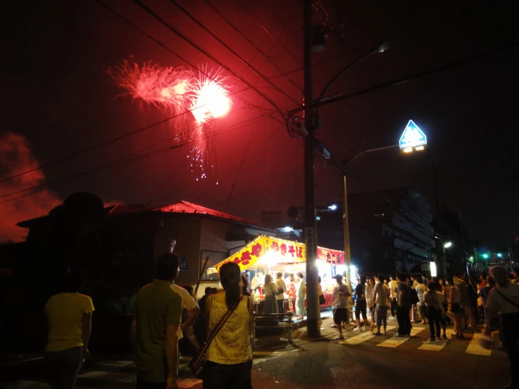a crowd is watching fireworks going off on a dark night