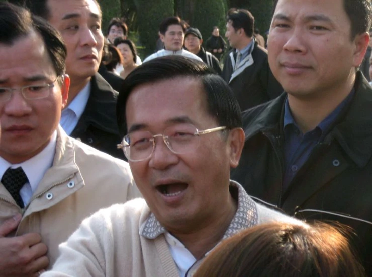 a group of asian men sitting next to each other