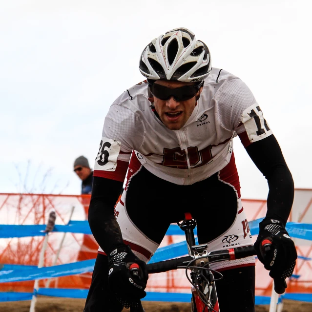 a man riding on the back of a bike down a dirt road