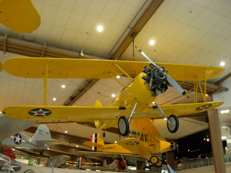 two airplanes are in an air museum with several people inside