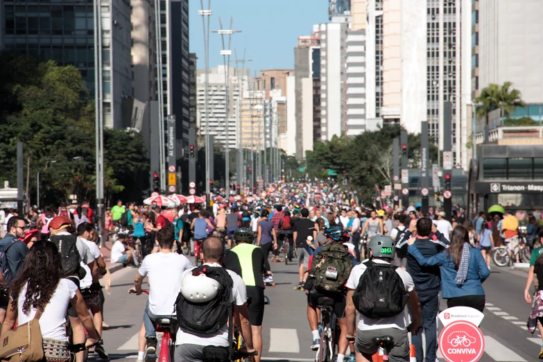 many people riding bikes on a city street