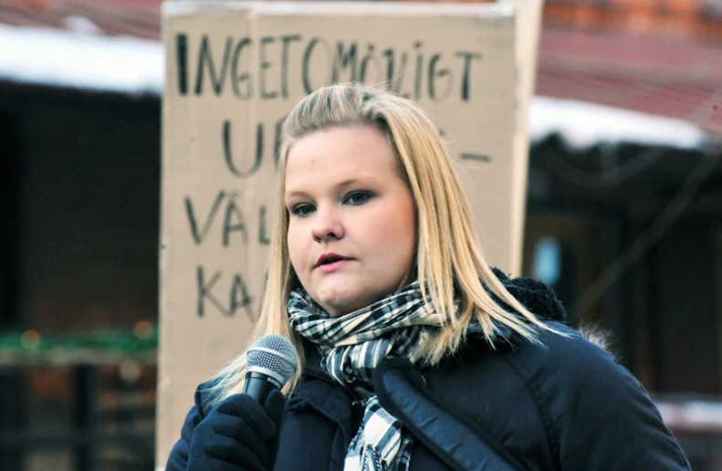 a woman with a scarf in front of a sign