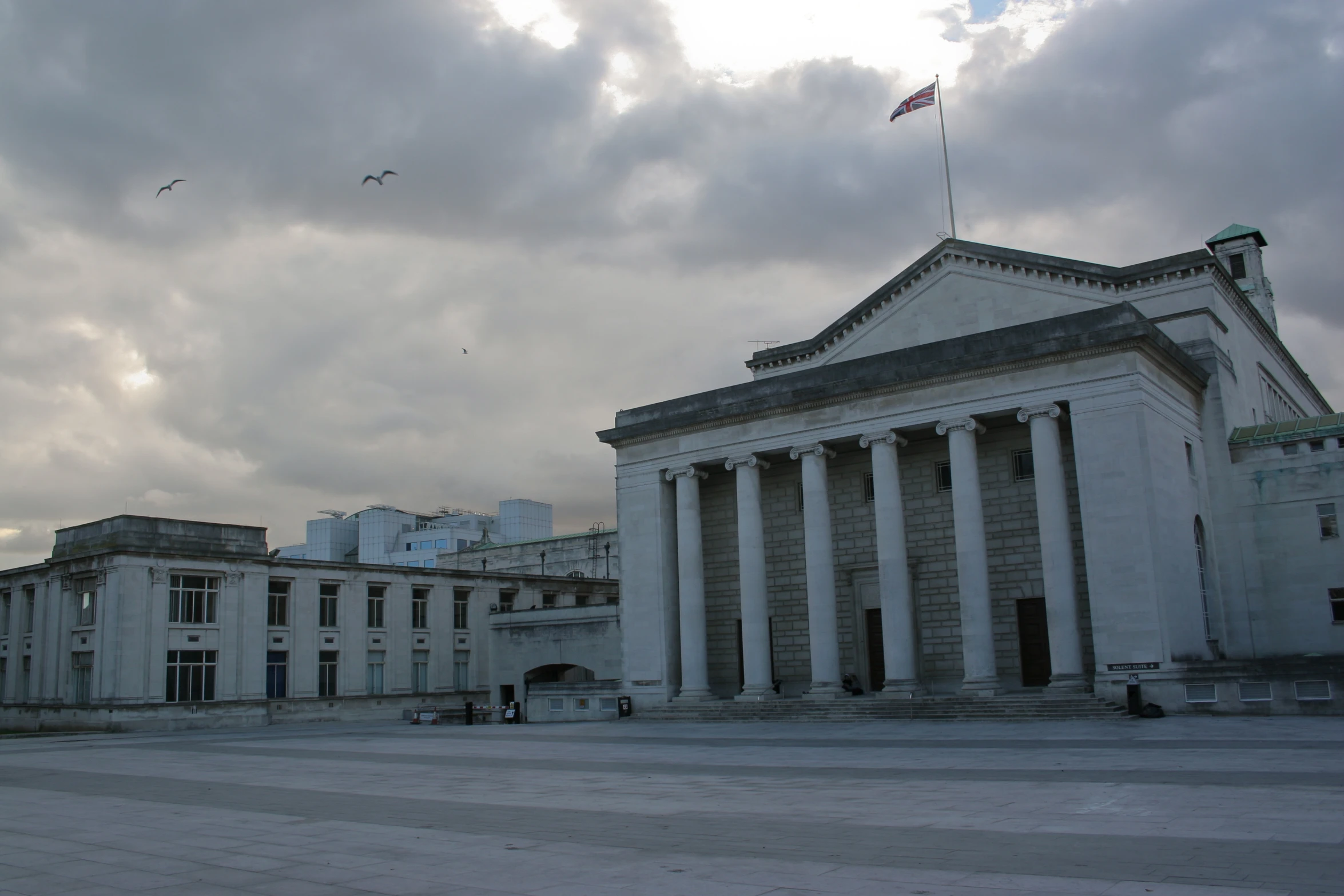 a large building with columns and a flag flying from the top