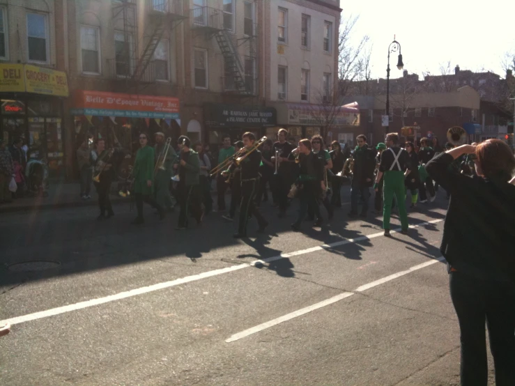 a man is standing in the street next to a marching band