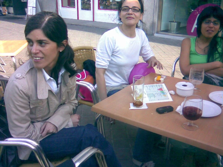 the woman sits at a table with two woman