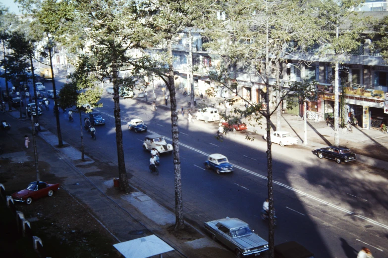 several cars traveling down a road in front of a building