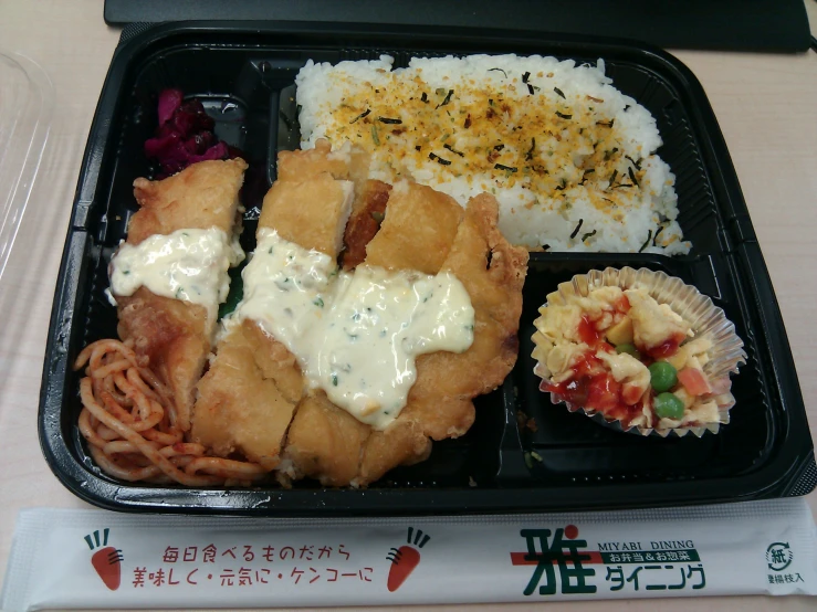 lunch container with rice, meats, and vegetables