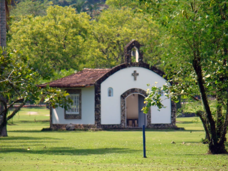 an outdoor church with large trees surrounding it