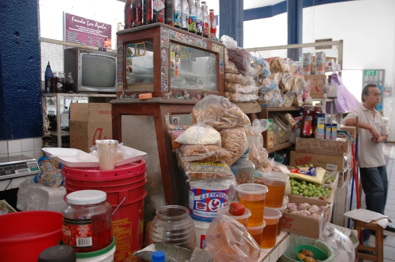 the man stands near some bread and drinks