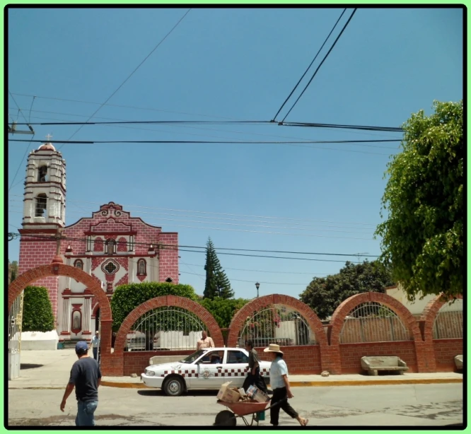 a family walking by the gate to a large brick church