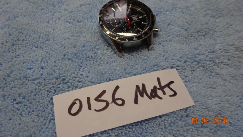 a piece of paper that has the date six minutes in it and a watch on the ground