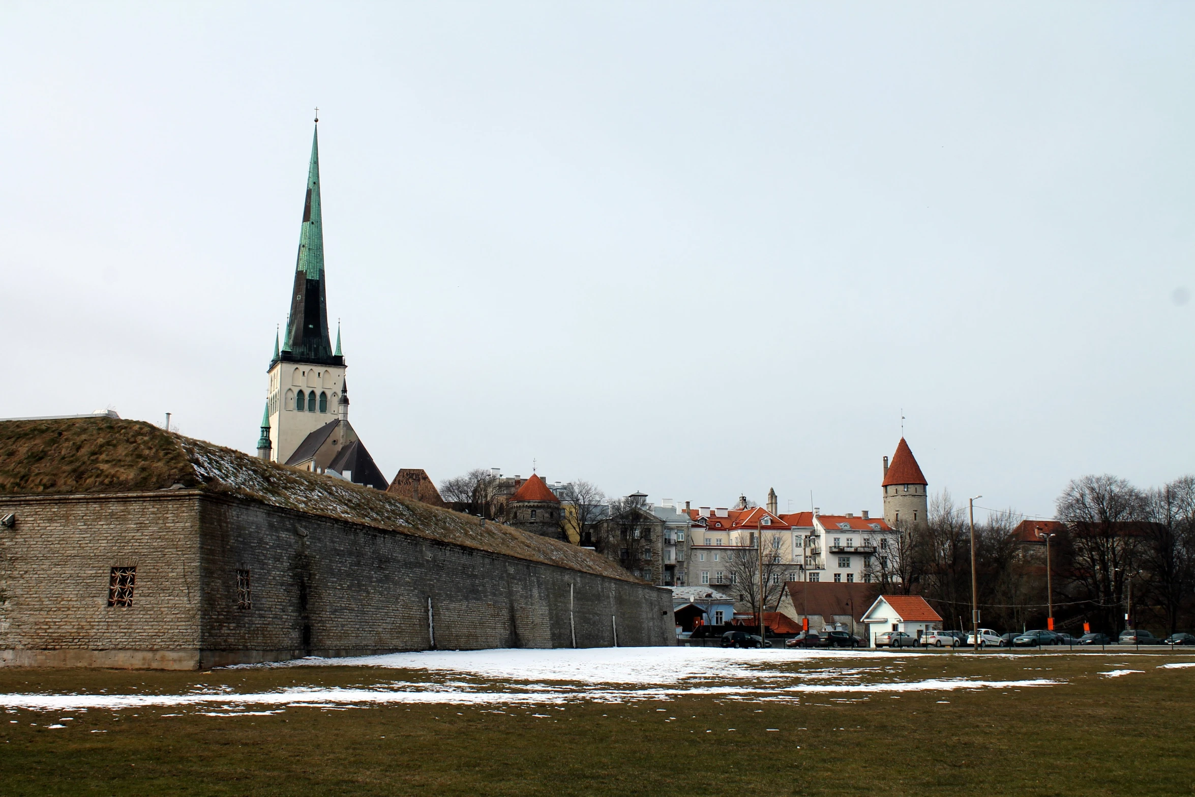 a castle like structure next to a field and a wall