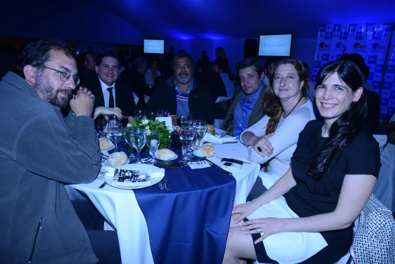 group of people sitting at a table having dinner