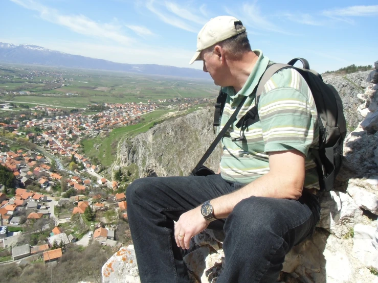 a man sitting on a rock overlooking a town