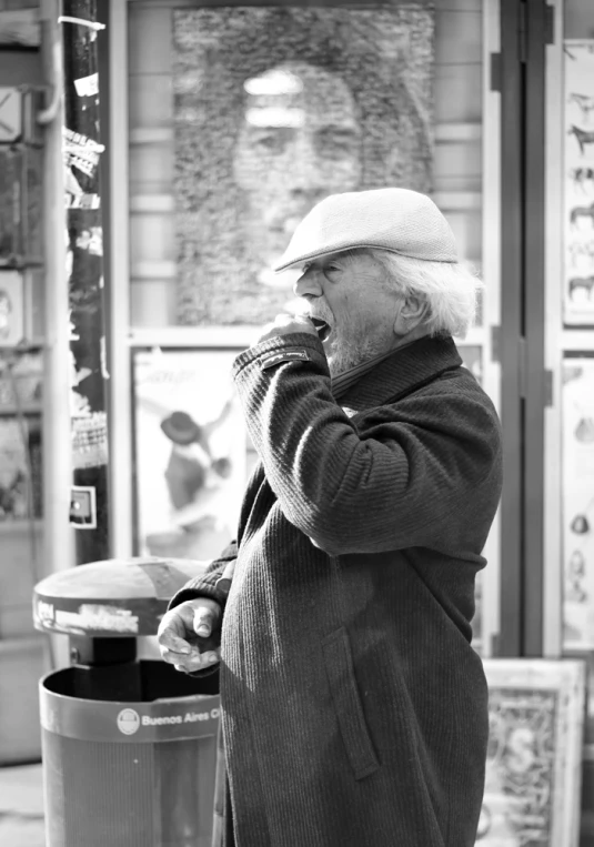 a man is standing by the garbage can