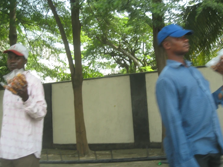 two men standing next to each other eating food