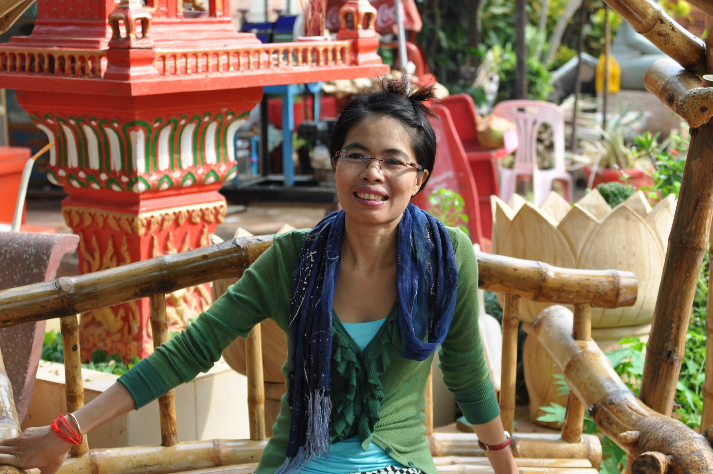 a woman sits on the back of a bench in a park