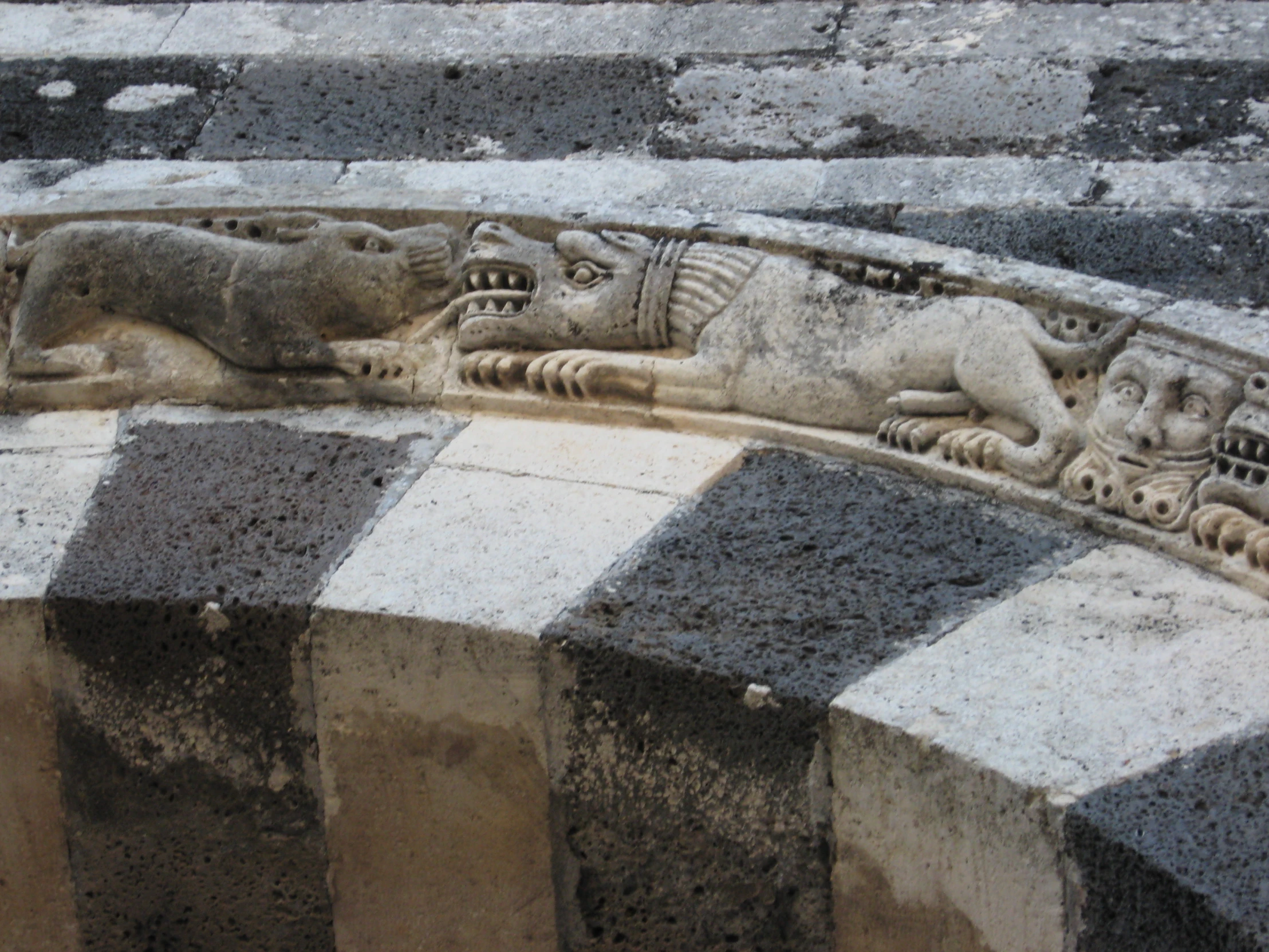 carved stone benches sitting on side walk near wall