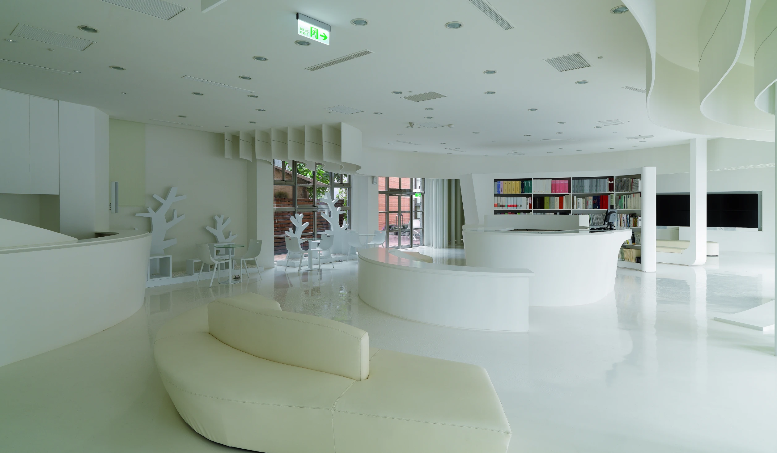 a white room with a circular desk on the far wall