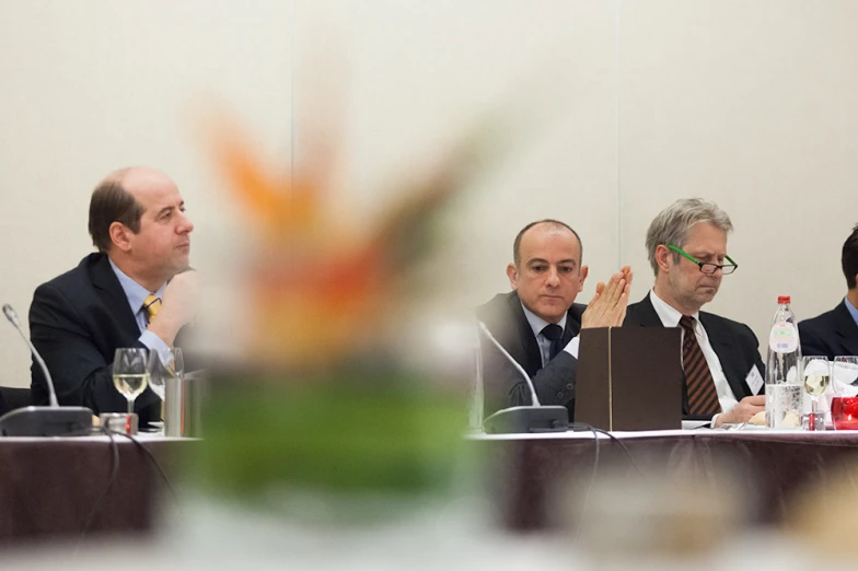 a group of men sitting at a table talking