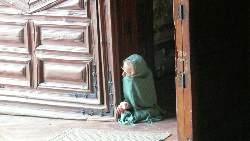 woman in green robes at door opening