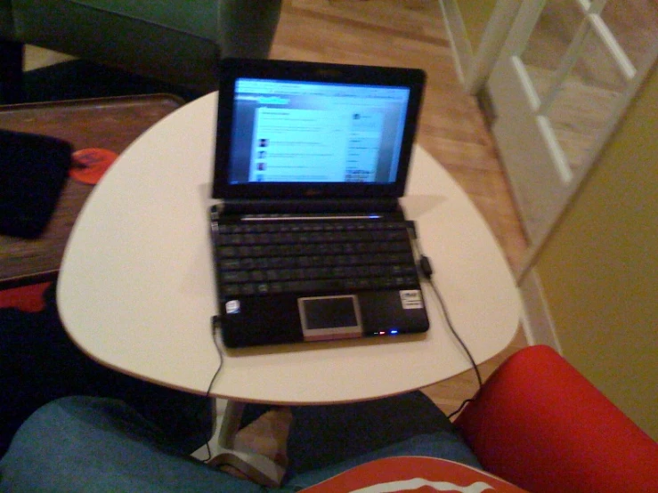 a laptop computer sitting on top of a small table