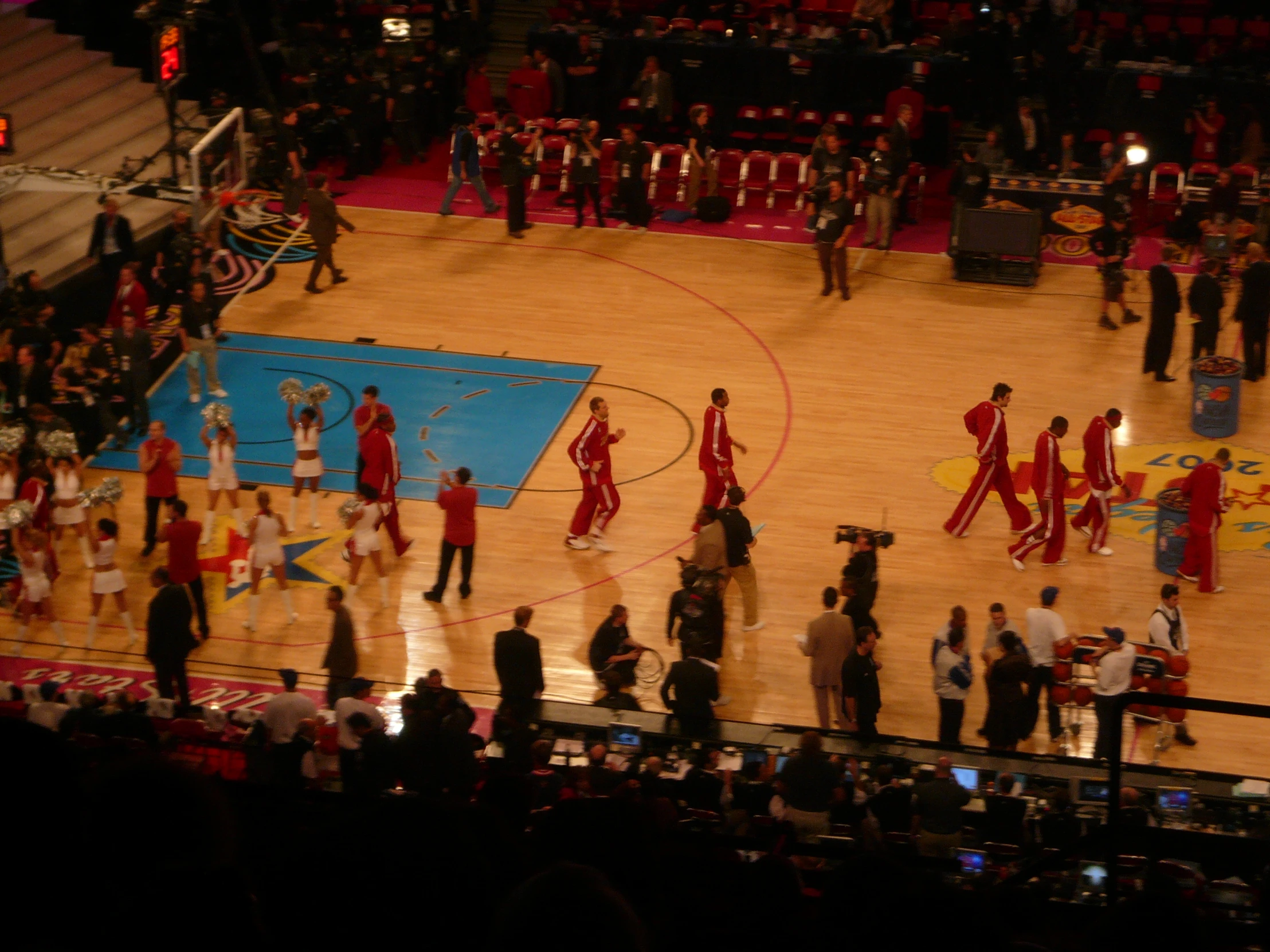 a large crowd in the stands watching a basketball game