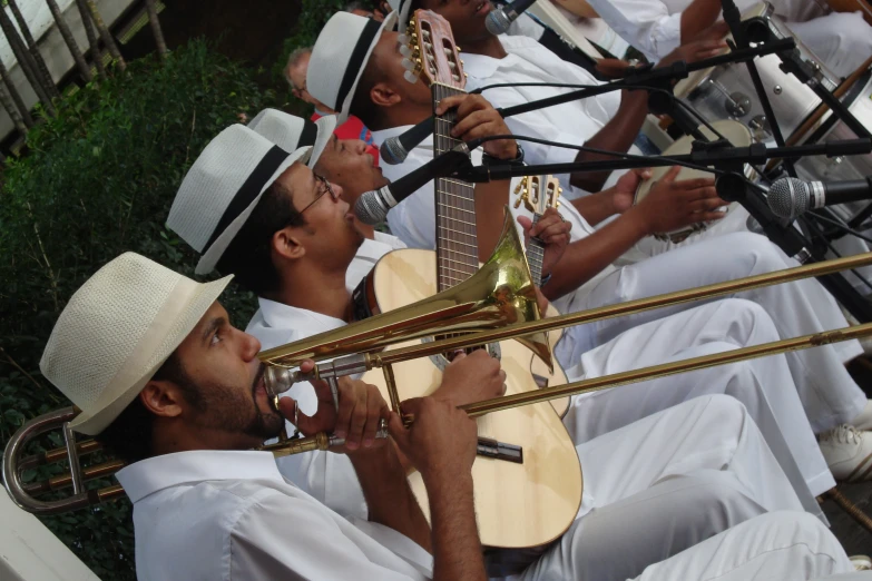 men dressed in white playing instruments while singing