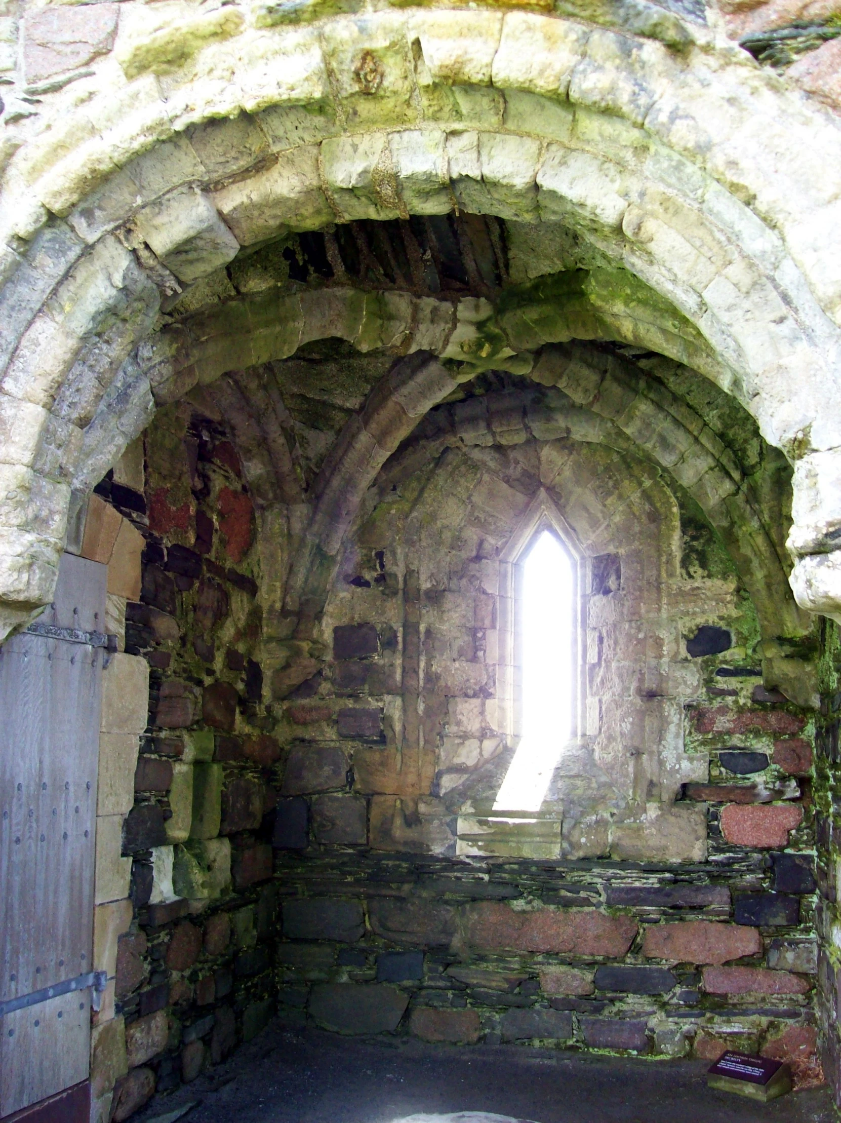 an arched window in the brick wall of a house