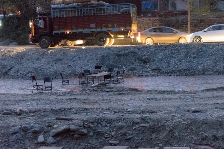 a construction truck driving down a road near a pile of rubble