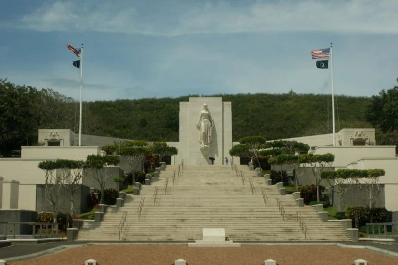 a very tall building with steps to a statue